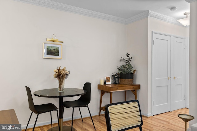 dining space featuring crown molding, baseboards, and wood finished floors