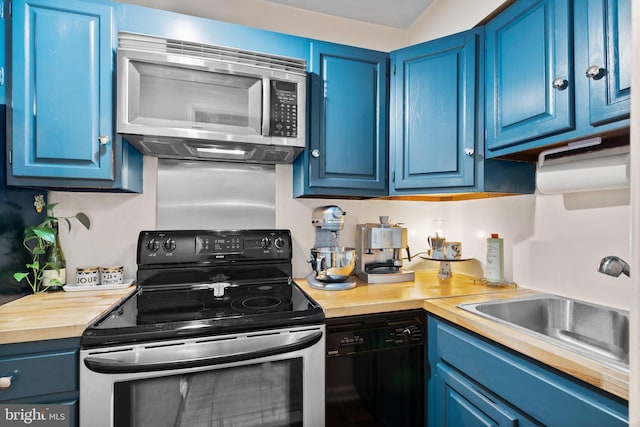 kitchen featuring a sink, blue cabinets, appliances with stainless steel finishes, and butcher block countertops