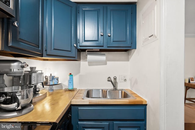 kitchen featuring stove, blue cabinets, and a sink