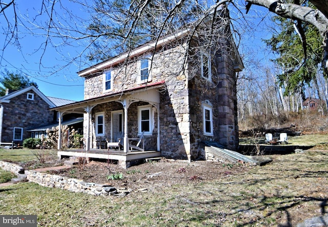 view of front of home with covered porch and stone siding