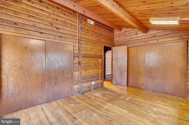 unfurnished bedroom with wood walls, wooden ceiling, lofted ceiling with beams, and wood-type flooring