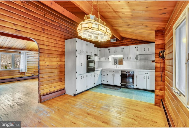 kitchen with a baseboard heating unit, black appliances, lofted ceiling with beams, and a sink