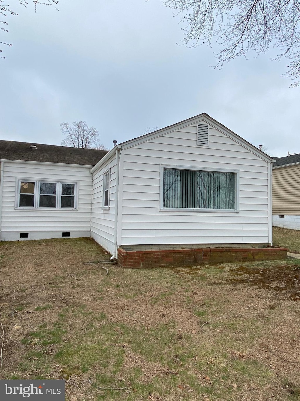 view of side of home featuring crawl space and a lawn