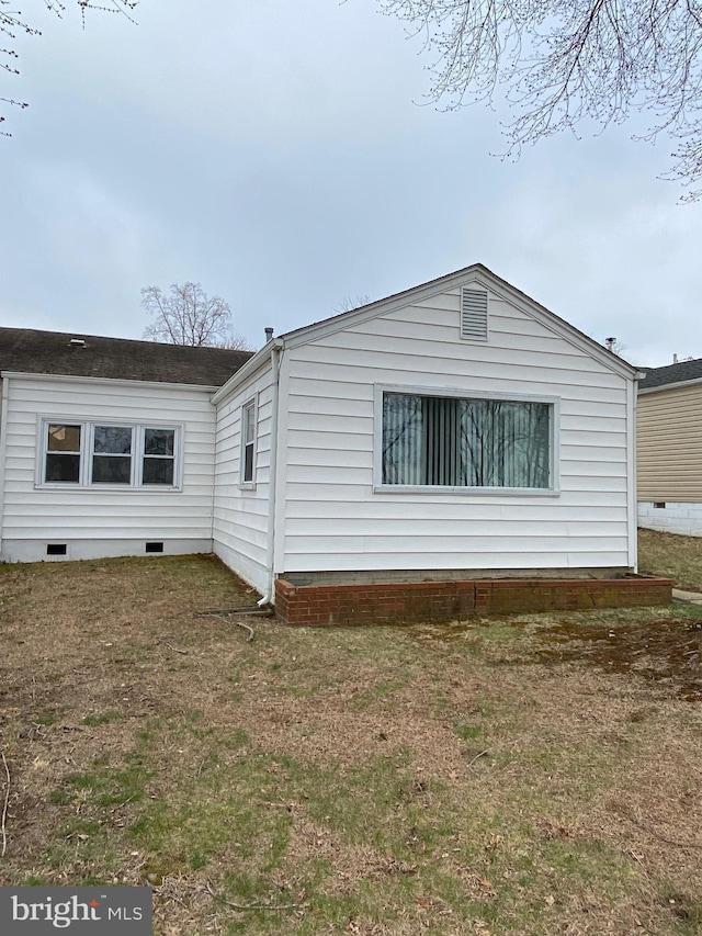 view of side of property featuring a yard and crawl space