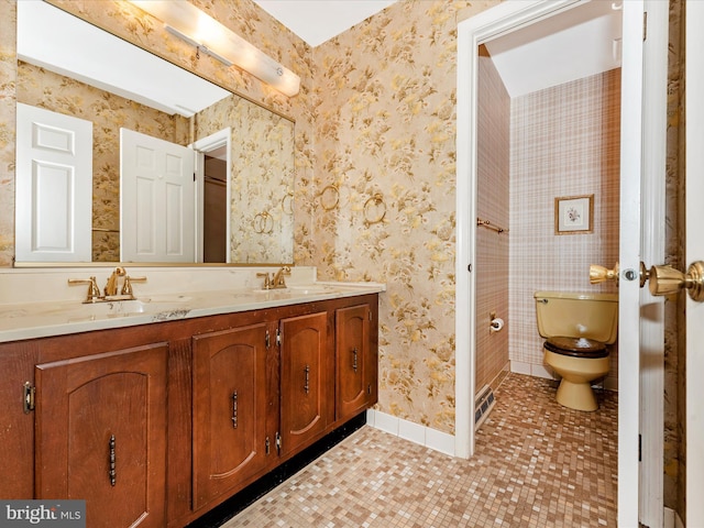 bathroom with toilet, a sink, wallpapered walls, tile patterned flooring, and double vanity