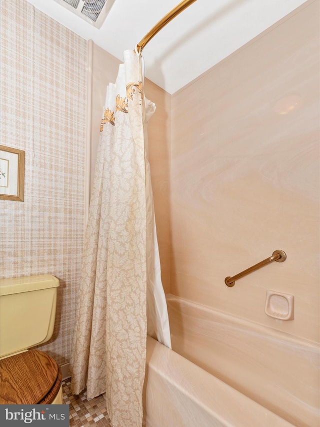 full bath featuring visible vents, toilet, and shower / bath combo with shower curtain