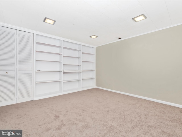 spare room featuring crown molding, baseboards, and carpet floors