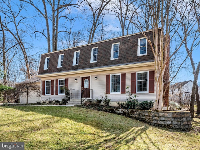 view of front facade featuring a front yard and a shingled roof