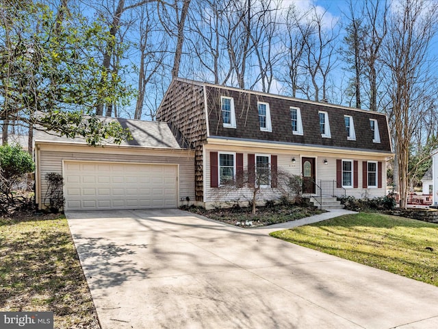 view of front of home featuring a front lawn, roof with shingles, concrete driveway, and an attached garage