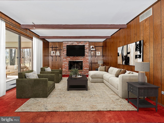 carpeted living room featuring visible vents, beamed ceiling, a brick fireplace, and wood walls