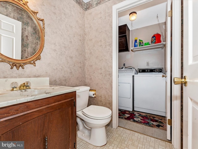 bathroom featuring washing machine and dryer, vanity, and toilet