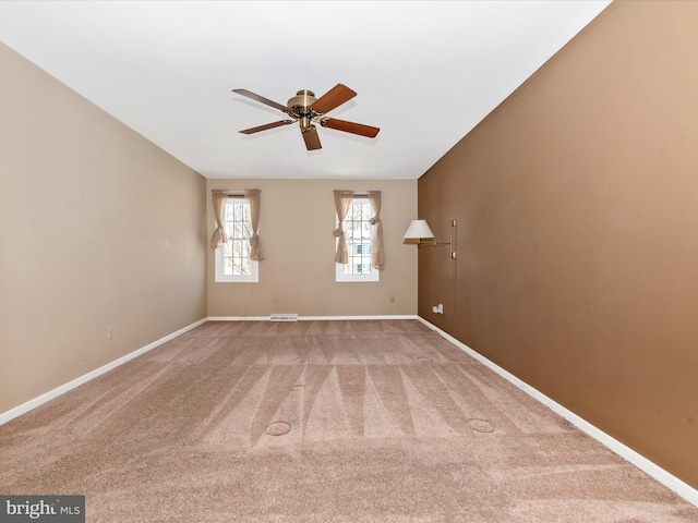 unfurnished room featuring carpet flooring, visible vents, baseboards, and a ceiling fan