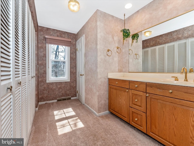 bathroom with visible vents, a closet, carpet flooring, baseboards, and vanity