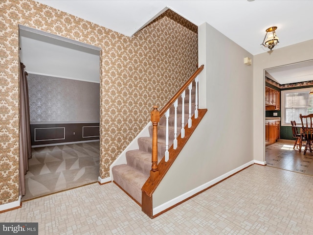 stairs featuring wallpapered walls and baseboards