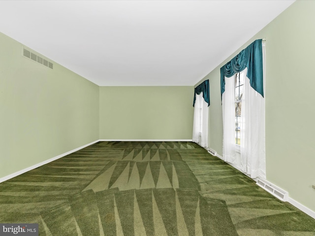 carpeted spare room with baseboards and visible vents