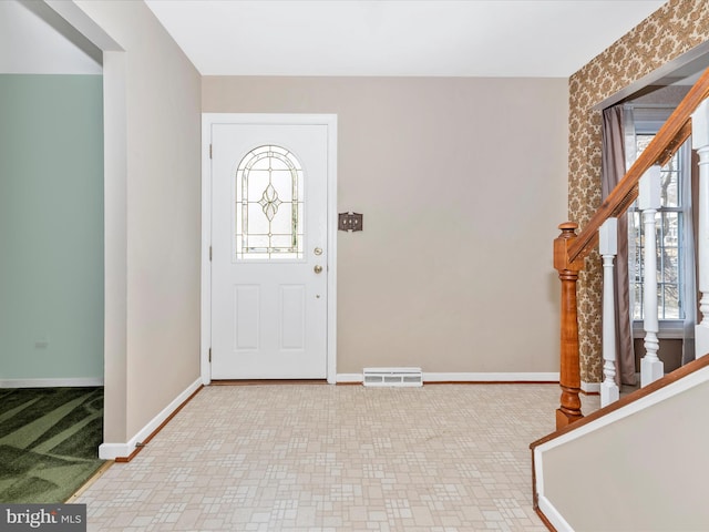 foyer entrance featuring stairway, plenty of natural light, and baseboards