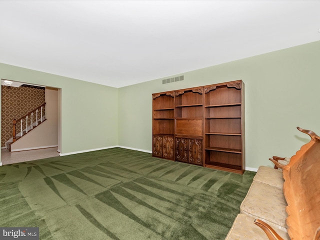 living room featuring visible vents, baseboards, carpet flooring, and stairway