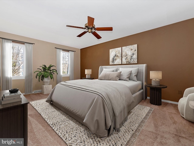 bedroom featuring light colored carpet, a ceiling fan, and baseboards