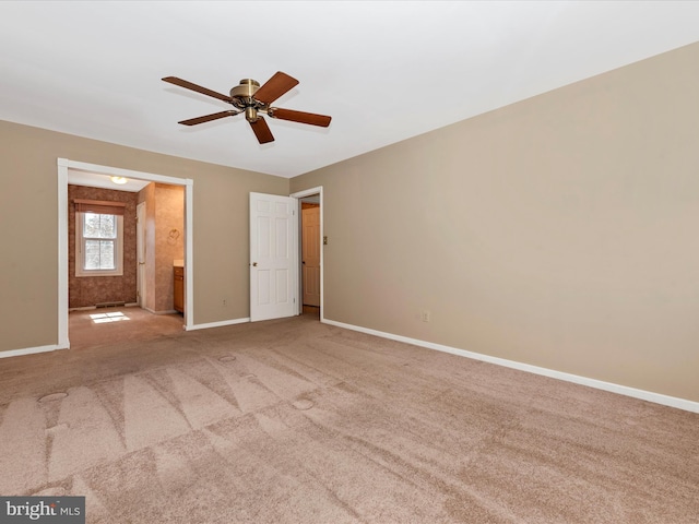 unfurnished bedroom with carpet flooring, a ceiling fan, ensuite bathroom, and baseboards