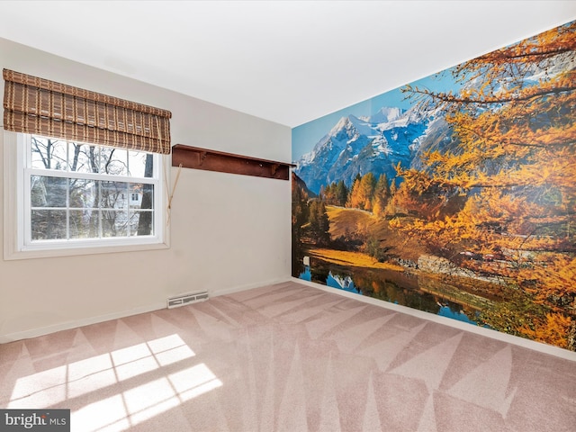 empty room featuring carpet, visible vents, and baseboards