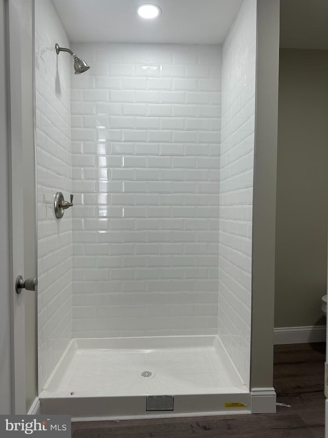 full bathroom featuring a stall shower and baseboards