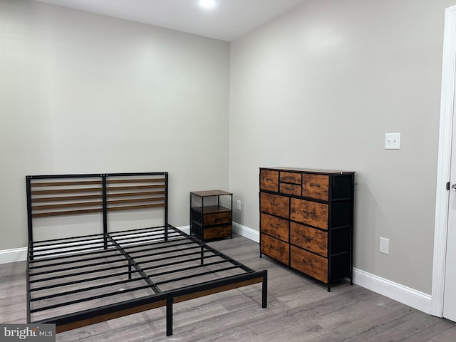 bedroom with wood finished floors and baseboards