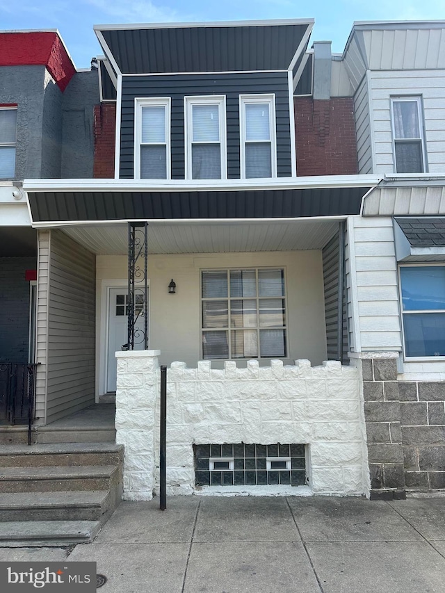 townhome / multi-family property featuring covered porch