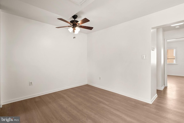 unfurnished room featuring baseboards, wood finished floors, and a ceiling fan