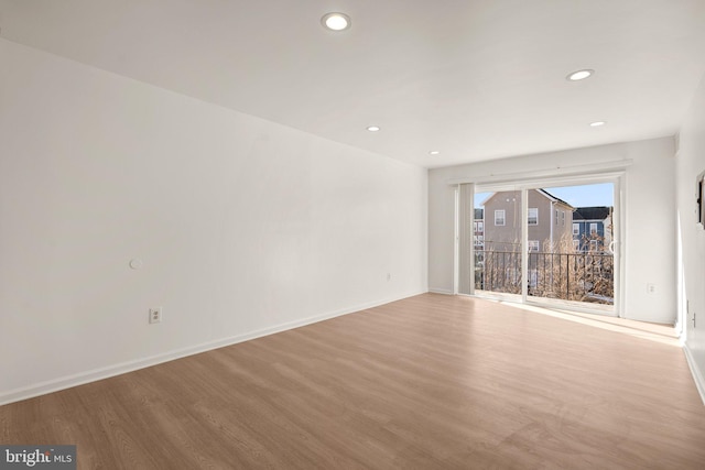 empty room featuring recessed lighting, wood finished floors, and baseboards