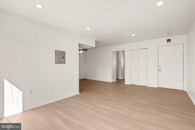 unfurnished living room with electric panel, light wood-type flooring, and recessed lighting