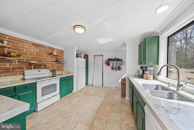 kitchen with ornamental molding, a sink, white appliances, green cabinets, and brick wall