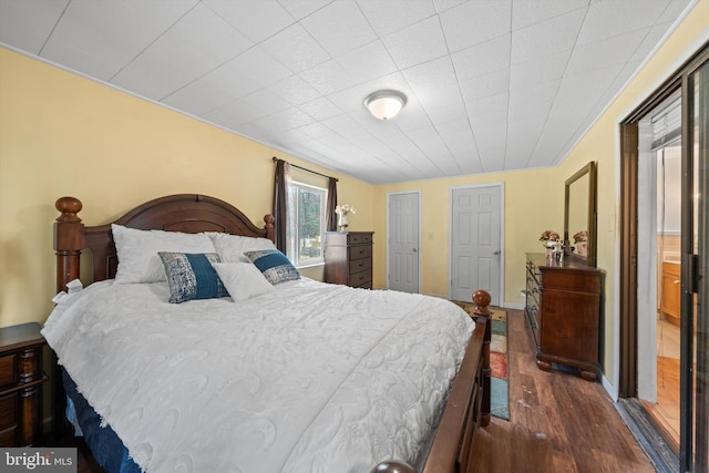 bedroom featuring baseboards and dark wood-style floors