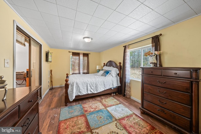 bedroom featuring baseboards and dark wood-style flooring