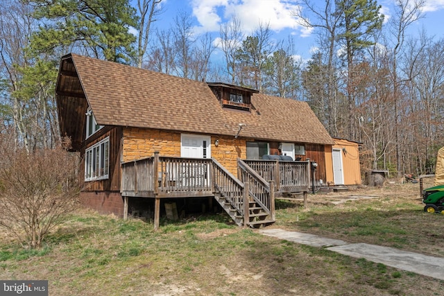 rustic home with a deck and a shingled roof