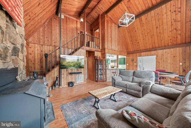 unfurnished living room with wood walls, beam ceiling, wooden ceiling, wood finished floors, and high vaulted ceiling