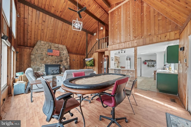 interior space with light wood-style flooring, beamed ceiling, wood ceiling, and wood walls