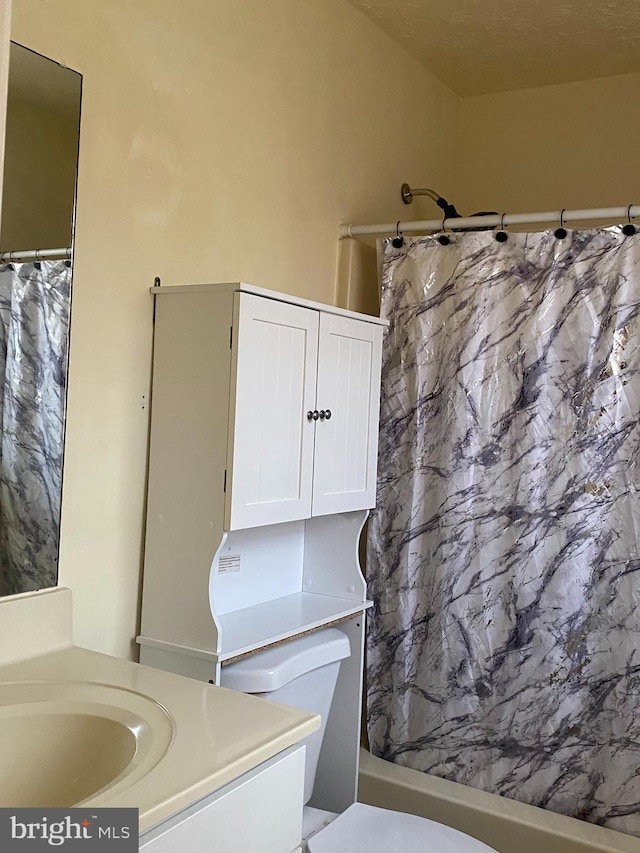 bathroom with toilet, vanity, and a shower with curtain