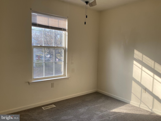 spare room featuring visible vents, baseboards, and carpet