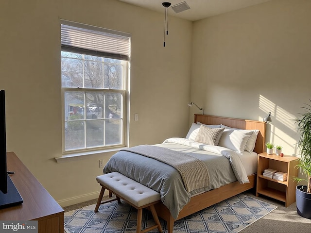 carpeted bedroom with visible vents and baseboards