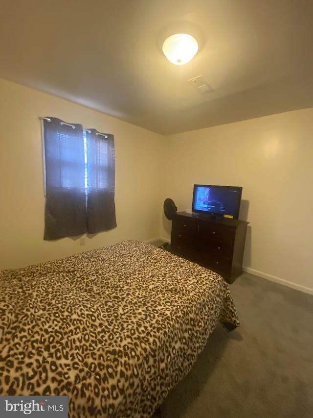 carpeted bedroom featuring visible vents and baseboards