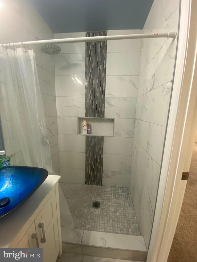 bathroom featuring vanity and tiled shower