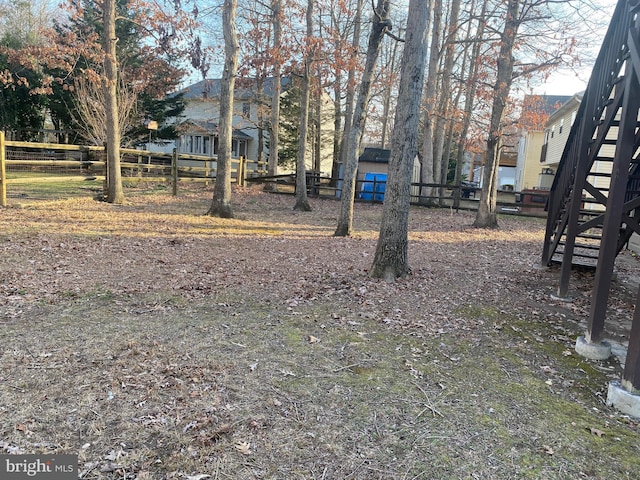 view of yard with stairs and fence