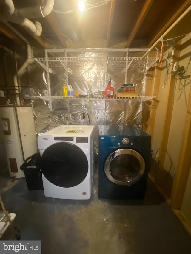 laundry area featuring electric water heater, washing machine and dryer, and laundry area