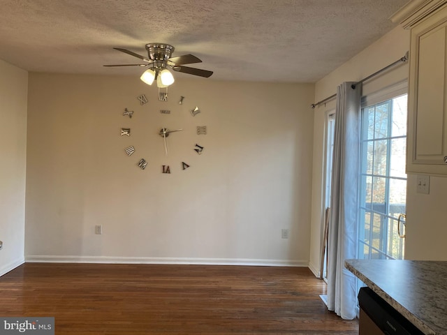 spare room with dark wood finished floors, a textured ceiling, and a ceiling fan