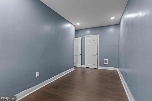 spare room with recessed lighting, visible vents, dark wood-style flooring, and baseboards