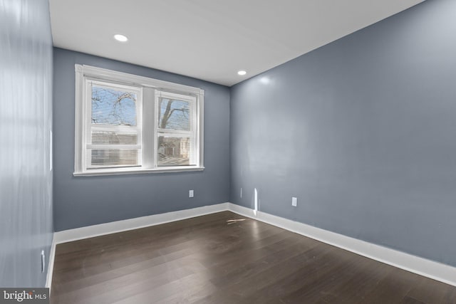 empty room featuring dark wood finished floors, recessed lighting, and baseboards