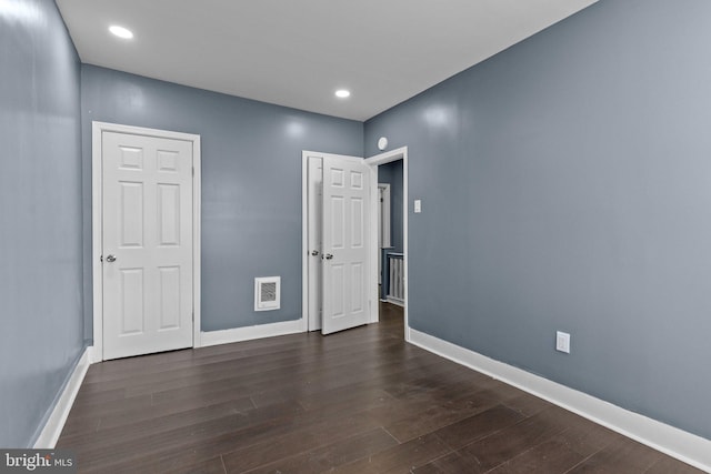 unfurnished bedroom with visible vents, baseboards, and wood finished floors