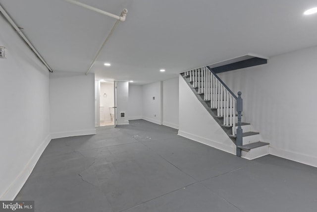 finished basement featuring stairs, recessed lighting, and baseboards