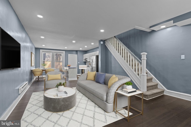 living room with wood finished floors, recessed lighting, baseboards, baseboard heating, and stairs