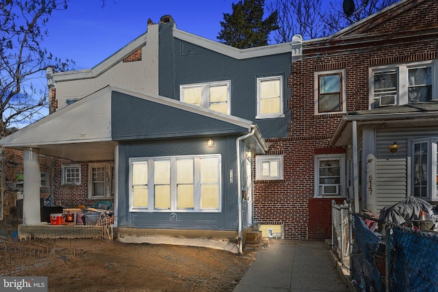 back of house featuring stucco siding and brick siding